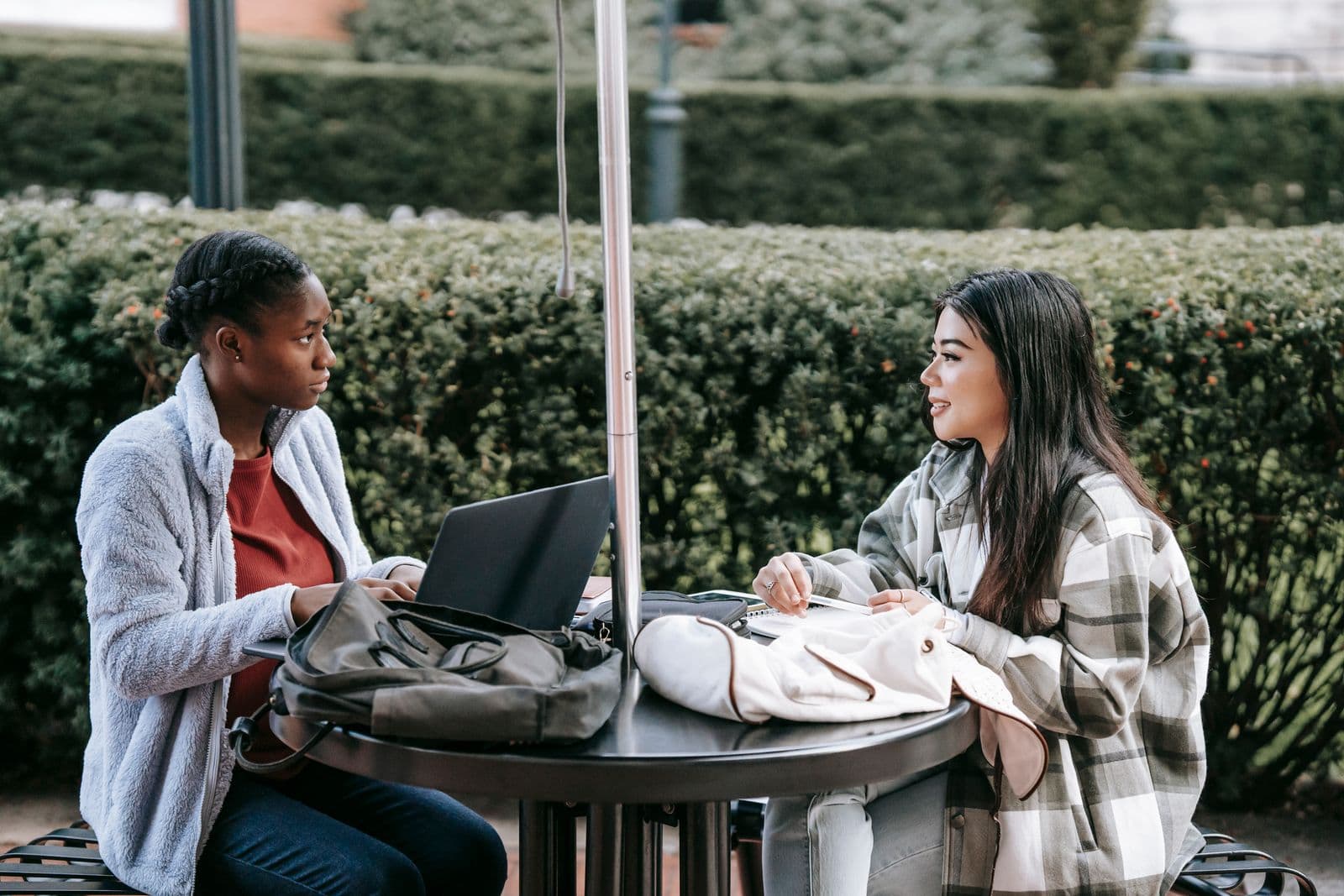 Two students collaborating on a laptop at a university campus
